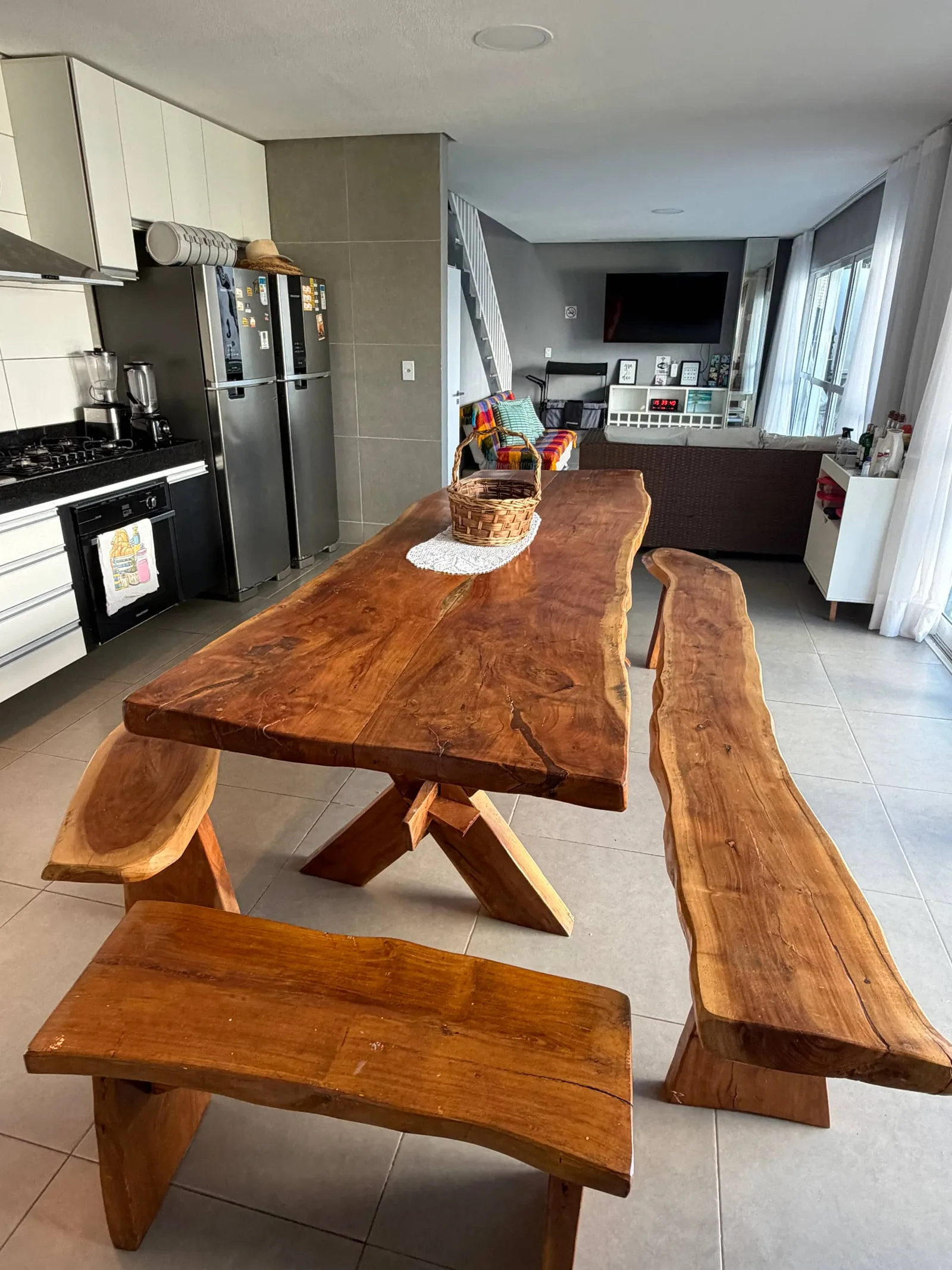 Cozinha gourmet integrada à sala, com mesa de madeira maciça de borda viva