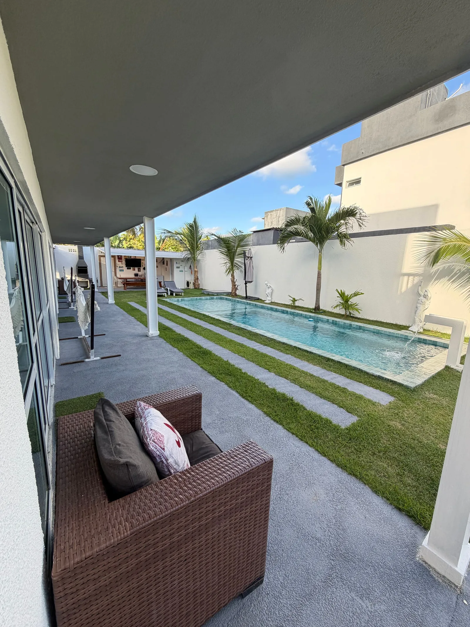 Espreguiçadeiras junto à piscina, cobertura branca ao fundo